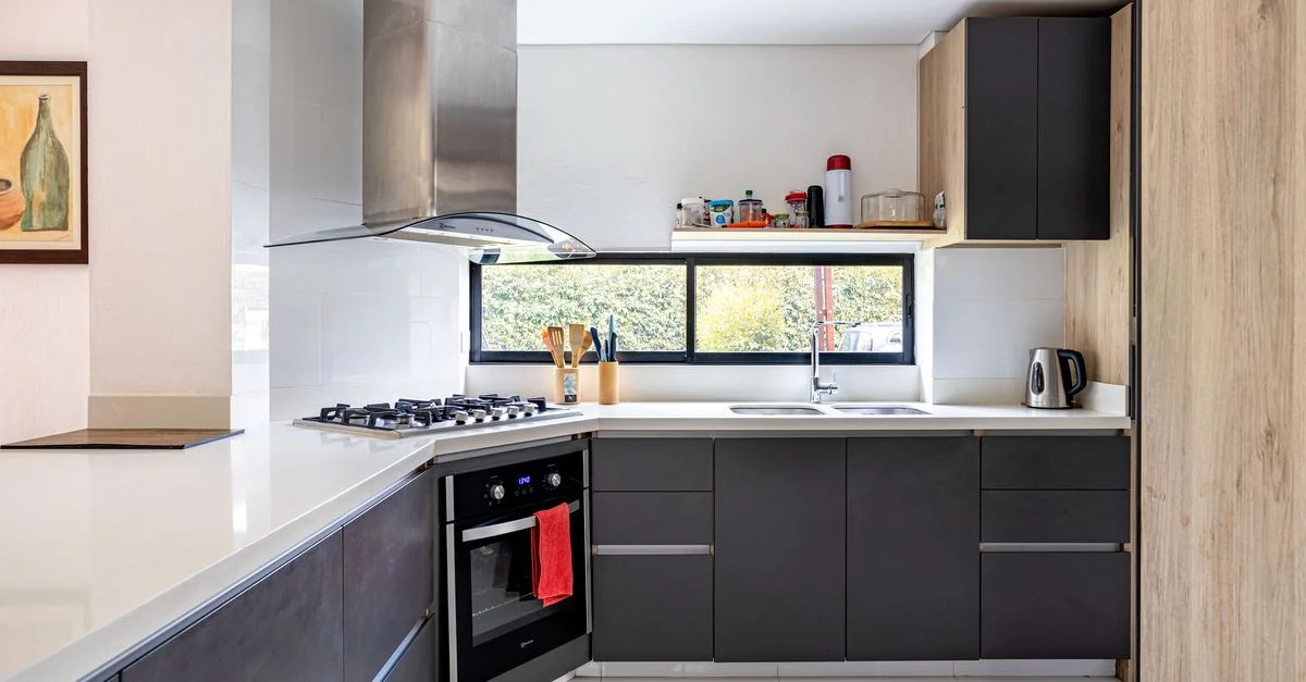 Moderno interior de cocina en Chía, Colombia, con armarios oscuros y elementos de acero inoxidable.